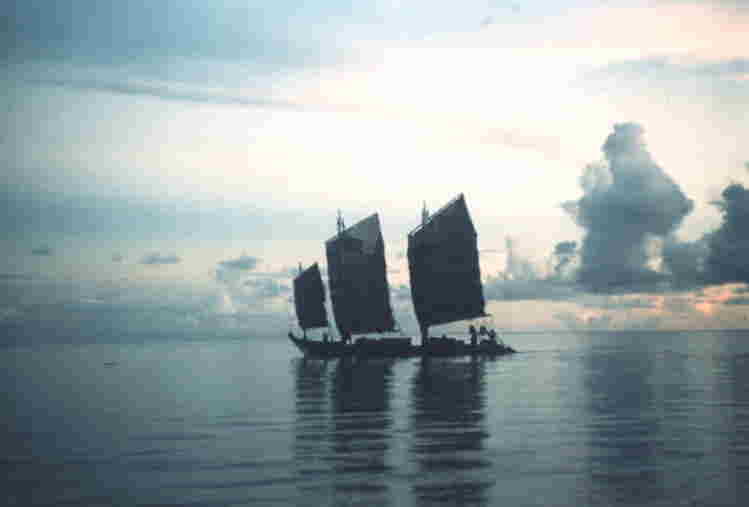 夕なぎのなか、静かに進む離島航路の帆船　〔昭和30年〈1955〉頃。石垣港地先〕写真提供・山里節子